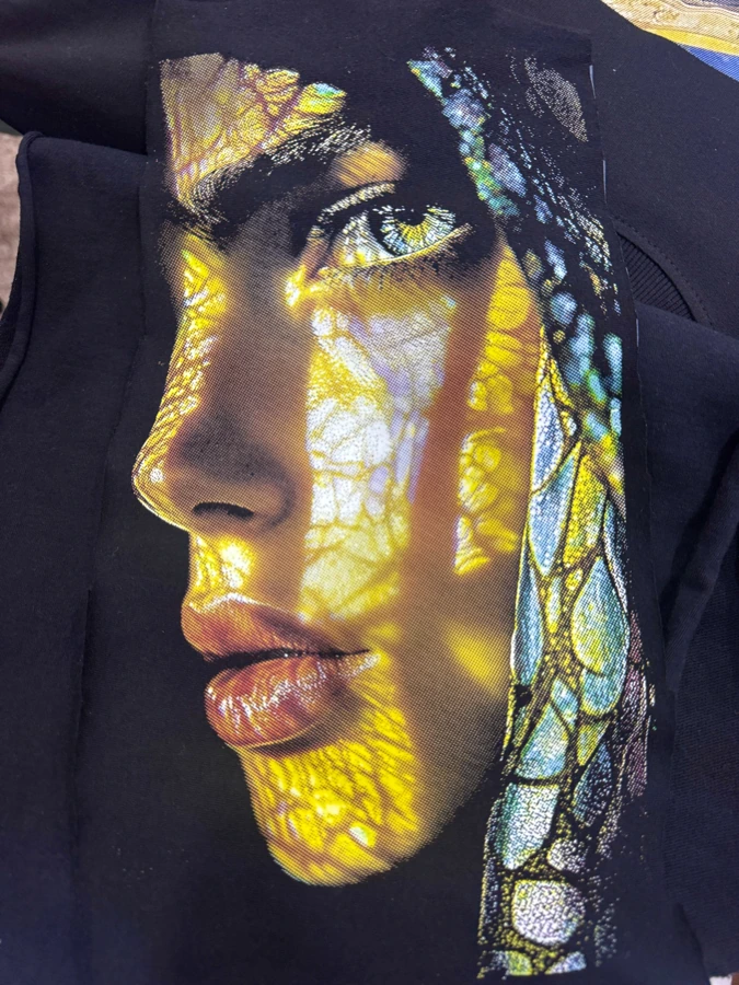 Close-up of a halftone DTF portrait showing fine printed dots and open fabric areas